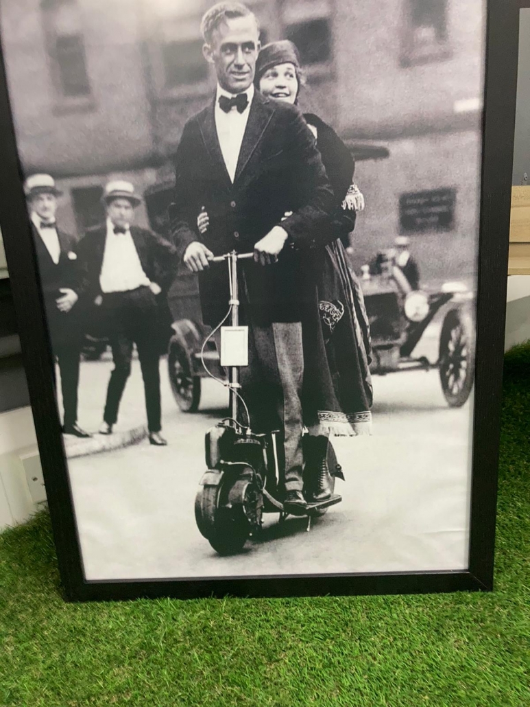 vintage photo of a gentleman riding an electric scooter